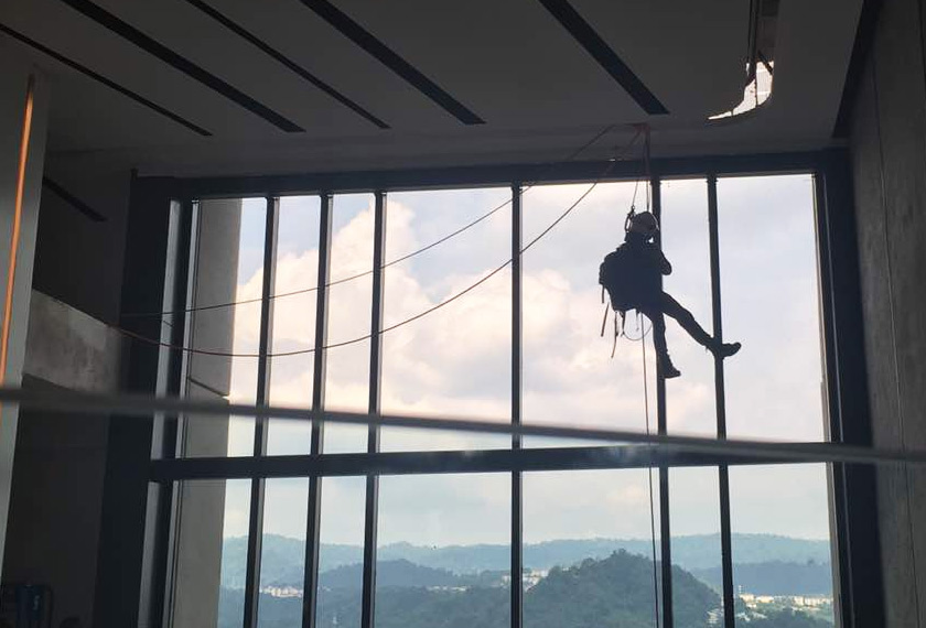Pihak bomba sedang cuba menyelamatkan kucing yang terduduk pada palang tingkap. - Astro AWANI.