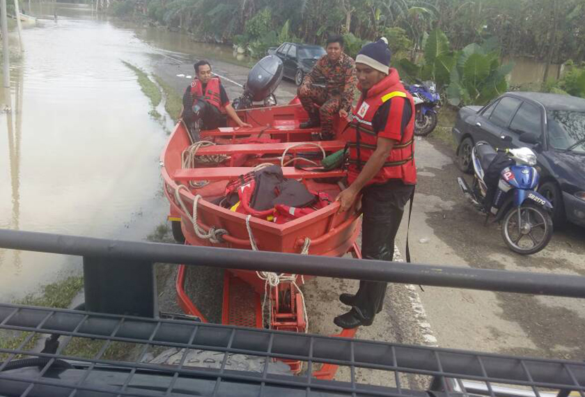 Anggota bomba membantu penduduk kampung di Kota Belud yang terjejas akibat banjir dalam operasi menyelamat pada petang Selasa. - Astro AWANI / RUZAINI ZULKEPLI
