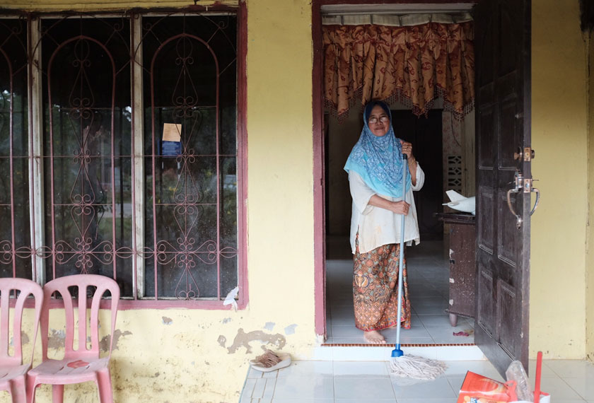 Rafeah menggunakan sehabis tenaganya untuk mengembalikan kebersihan rumahnya selepas dilanda banjir. - Foto Astro AWANI