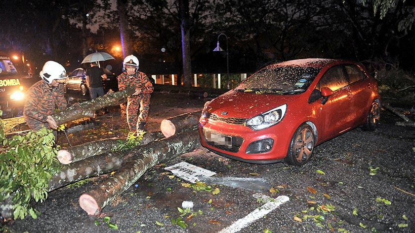 Seorang Kakitangan Universiti Islam Antarabangsa (UIA) bersama anggota keluarganya melihat kenderaan mereka yang ranap pada bahagian bumbung di kawasan UIA hari ini.  - Foto Bernama