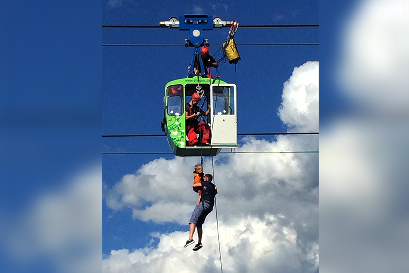 Kanak-kanak dilihat berpaut pada ibu bapa mereka setinggi 40 meter dari aras sungai. - Foto Rainer Jensen/dpa via AP