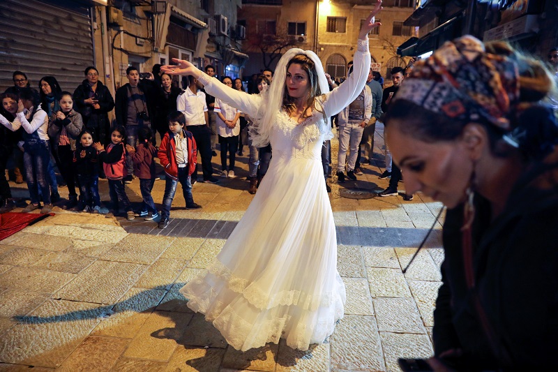 A woman dances as Arab and Jewish players compete in a backgammon championship organised by Double Yerushalmi, a group trying to build closer ties between Arabs and Jews through cultural activities, in Jerusalem February 27, 2017. Picture taken February 27, 2017. REUTERS/Ammar Awad