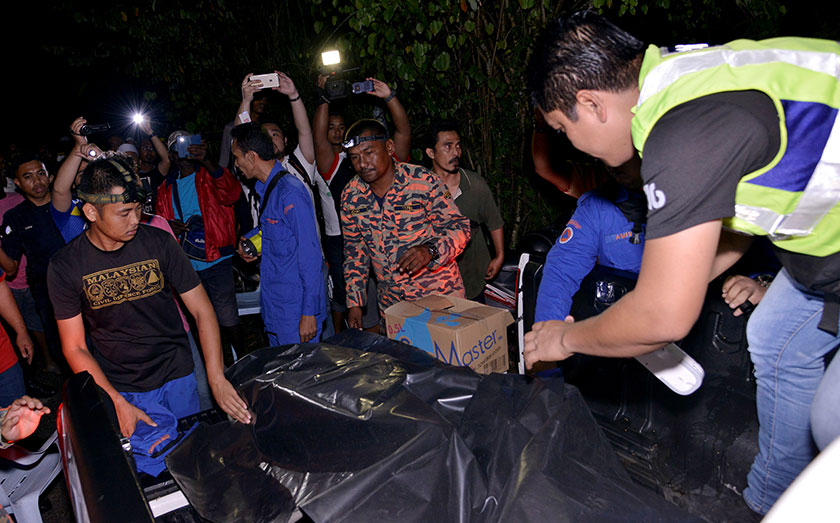 Anggota Polis dan Bomba membawa keluar mayat mangsa lemas yang dijumpai di Kampung Timah SKC Bukit Beruntung hari ini. - Foto Bernama
