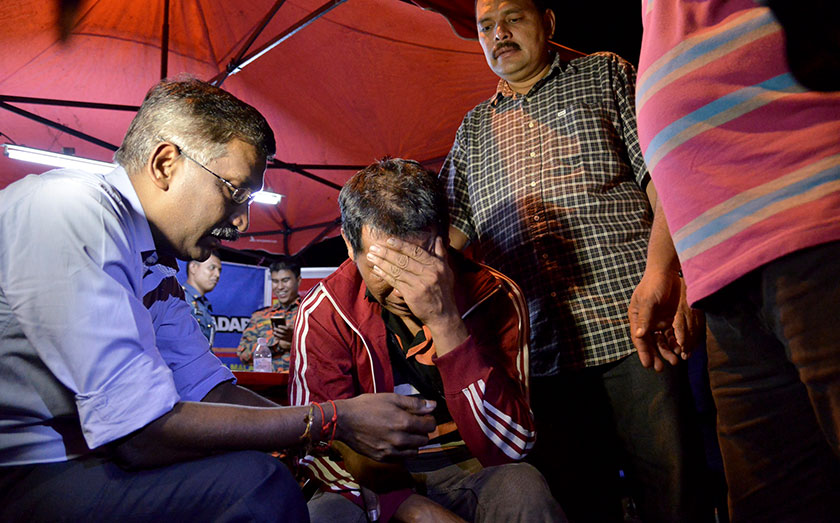 Anggota Parlimen Hulu Selangor Datuk Seri P. Kamalanathan mententeramkan seorang anggota keluarga mangsa lemas di Kampung Timah SKC Bukit Beruntung hari ini. - Foto Bernama