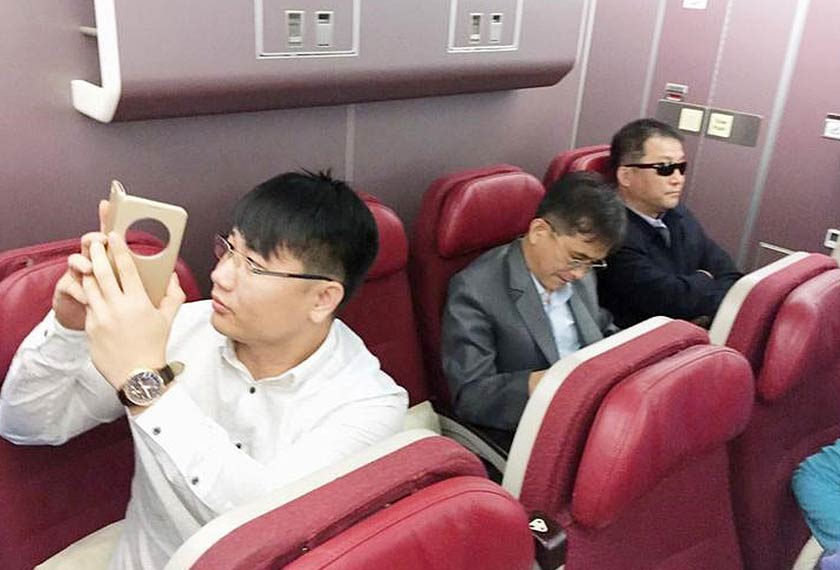 Passengers believed to be North Koreans including Kim Uk Il (L) are seen inside an airplane for the flight bound for Beijing. -Kyodo/via REUTERS