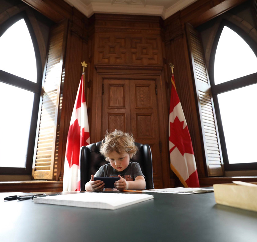 Malah, Hadrien, 3 turut kelihatan duduk di kerusi bapanya sambil bermain telefon pintar. - Foto Facebook Justin Trudeau