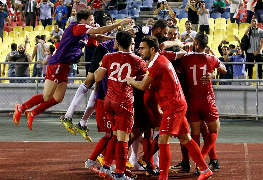 Teammates celebrate with Syria's Omar Al Soma after he converted a penalty kick at the Hang Jebat Stadium in Melaka. - REUTERS