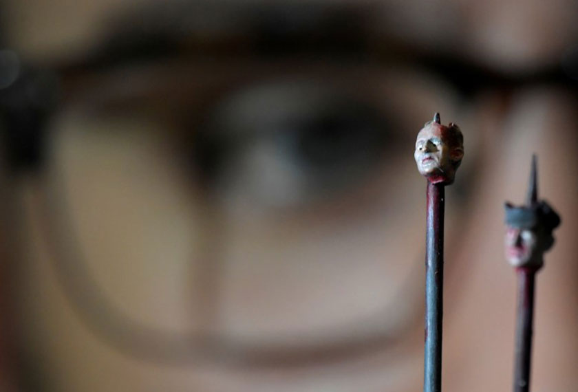 An employee poses as he views 'My Cat Went to See Hell and All I Got Was This Lousy Souvenir' by Jake and Dinos Chapman, which forms part of the charity auction for the survivors of the London Grenfell Tower fire, at Sotheby's in London, Britain on Oct 12, 2017. - REUTERS