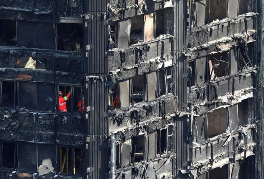 Members of the emergency services work inside burnt out remains of the Grenfell apartment tower in North Kensington, London, Britain, June 18, 2017. - REUTERS
