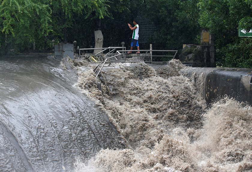 A man takes a picture of floodwaters in Las Pinas, Metro Manila as a storm sweeps across the main Luzon island, Philippines on Sept 12, 2017. - REUTERS