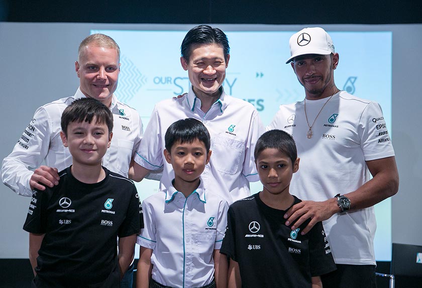 Valtteri Bottas (kiri), bersama rakan sepasukannya Lewis Hamilton dan Pengurus Teknologi Minyak Chan Ming Yau (tengah).