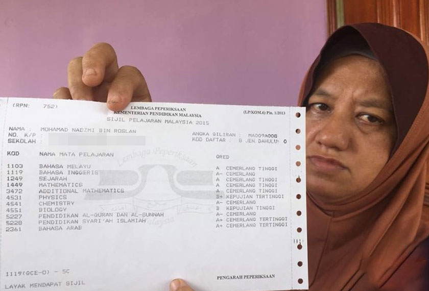 Noraishah Nordin menunjukkan slip peperiksaan SPM anaknya yang cemerlang.