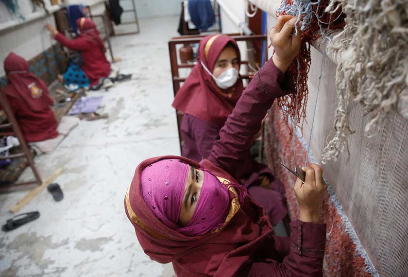 Golongan wanita Afghanistan ini masih gigih menganyam simpulan benang dari bulu-bulu biri-biri dan unta untuk menghasilkan lembaran permaidani. - Reuters
