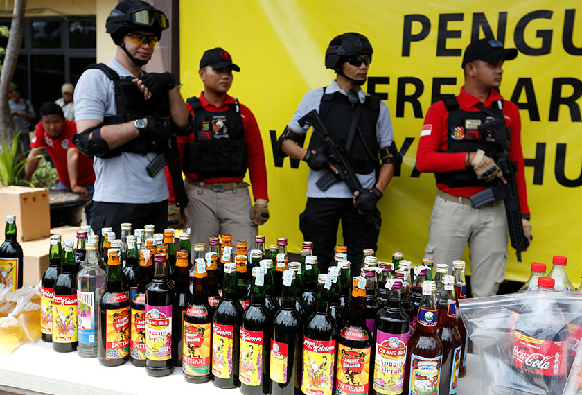 Polis Republik Indonesia pada Jumaat memusnahkan ribuan botol arak buatan sendiri dalam usaha mengekang kejadian hampir 100 maut. - Foto Reuters