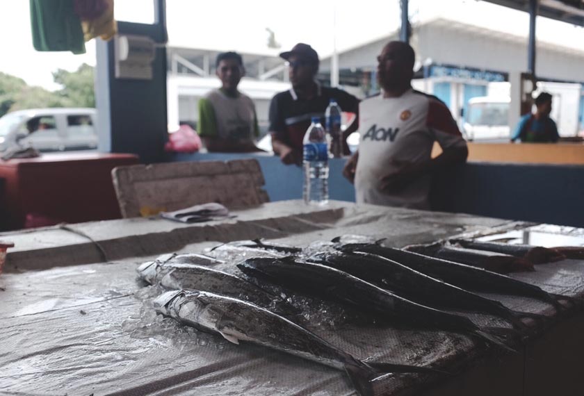 Jalal si penjual ikan sedang bersembang dengan rakan peniaga yang lain sambil menunggu pelanggan.