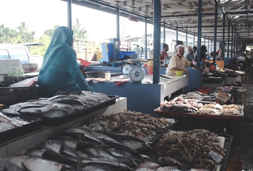 Para peniaga bersembang sesama sendiri sambil menunggu pelanggan.