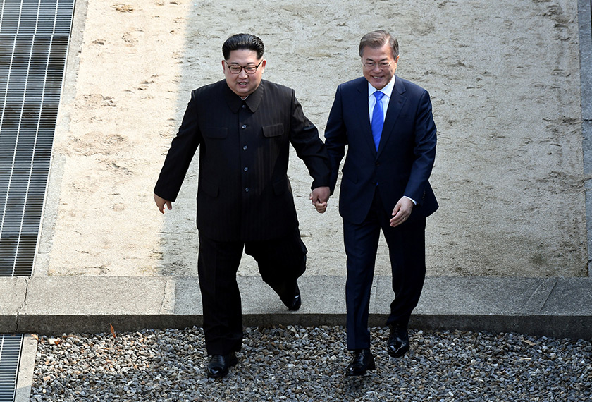 Jong-Un menjemput presiden Korea Selatan untuk melangkah melintasi garisan sempadan Korea Utara, sambil memegang tangan - Foto Reuters