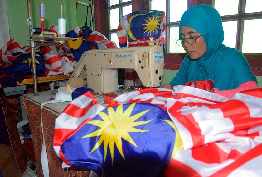 Setahun sekali, kedai jahit Sabariah akan dipenuhi Jalur Gemilang yang merupakan metrial untuk dijadikan baju tempahan pelanggan-pelanggannya. - Bernama