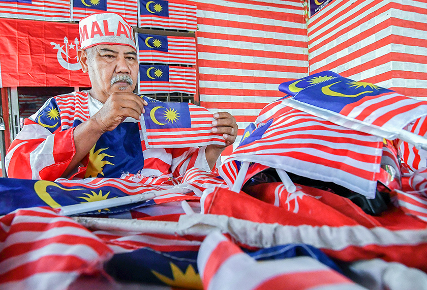 Muhammad Nasir mengutip Jalur Gemilang yang jatuh di tepi jalan, rosak mahupun koyak sejak tahun 2000 lagi. - Bernama