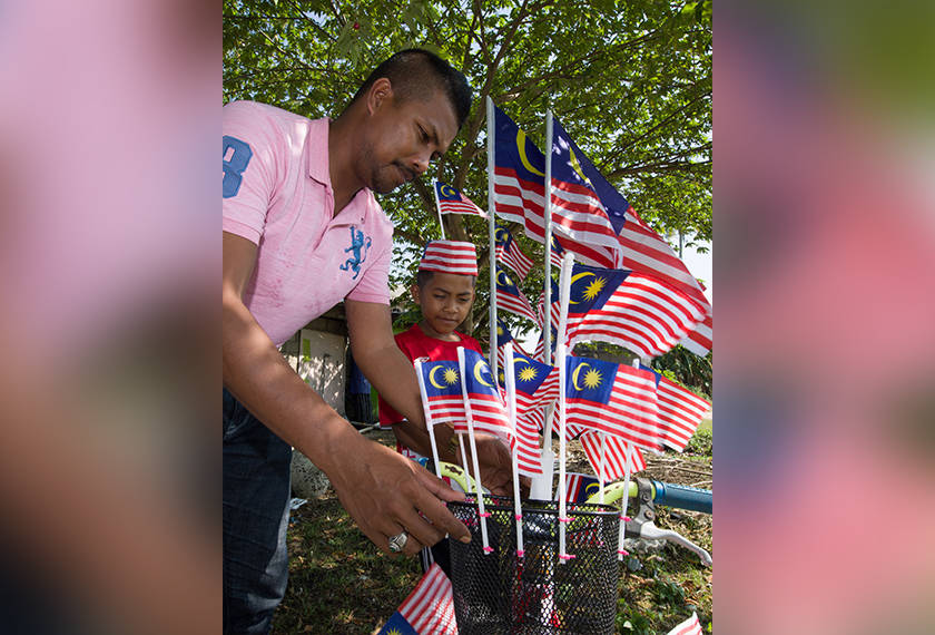 Sapian menunjukkan kreativiti menghias basikal anaknya dengan Jalur Gemilang bagi menunjukkan semangat patriotik yang tinggi sempena sambutan Bulan Kebangsaan Ke-61 di Kampung Banggol. --fotoBERNAMA