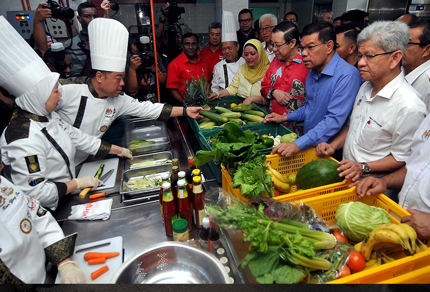 Guan Eng (tiga, kanan) bersama Saifuddin Nasution (dua, kanan) ketika lawatan di pusat operasi Food Bank hari ini. - BERNAMA