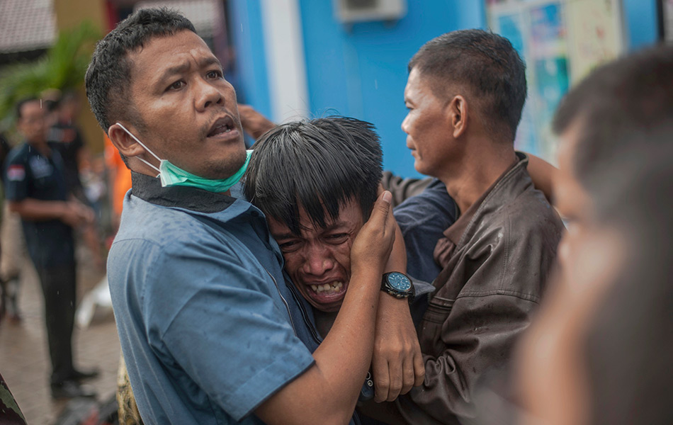 Seorang lelaki hiba selepas mengetahui saudaranya merupakan antara yang maut ketika tsunami melanda di Carita, Indonesia, 23 Dis, 2018. (Foto AP)