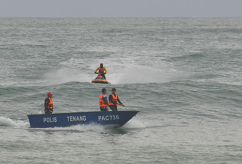 Anggota Polis melakukan pencarian mayat tiga beradik yang lemas di permukaan air Pantai Sura Tengah hari ini. - BERNAMA