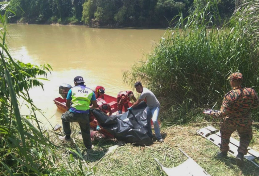 Pasukan bomba dan penyelamat cuba membawa naik mayat mangsa.
