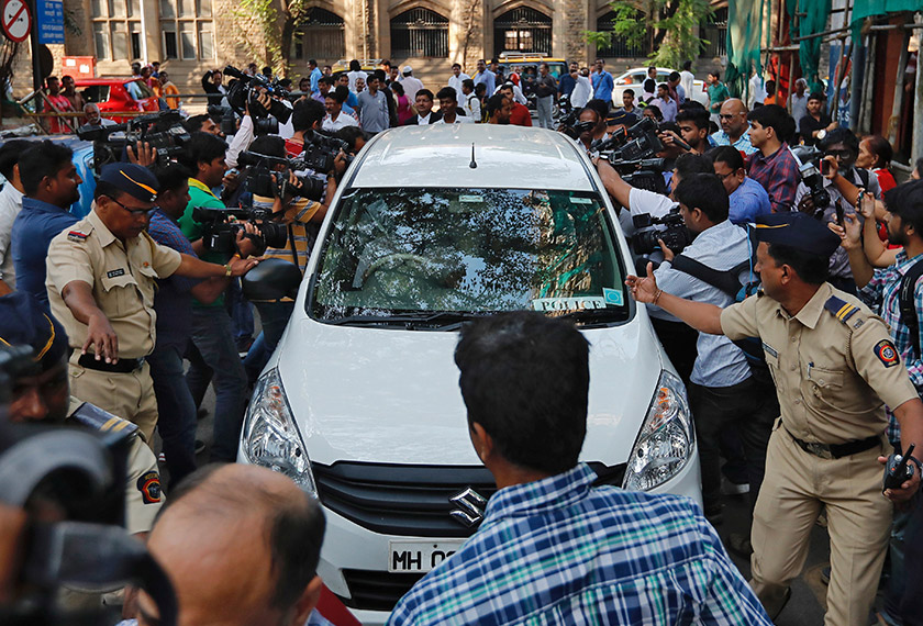 Police make way for a vehicle carrying three people suspected of steering fraudulent loans to companies linked to billionaire jeweller Nirav Modi, at a court in Mumbai, India, Feb 17, 2018. - REUTERS
