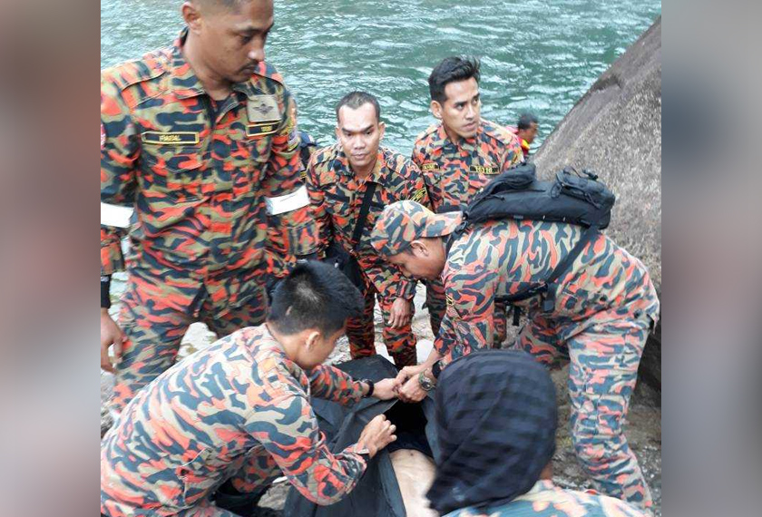 Anggota pasukan mencari dan menyelamat menguruskan mayat salah seorang mangsa sejurus selepas ditemui. - Foto ihsan Bomba