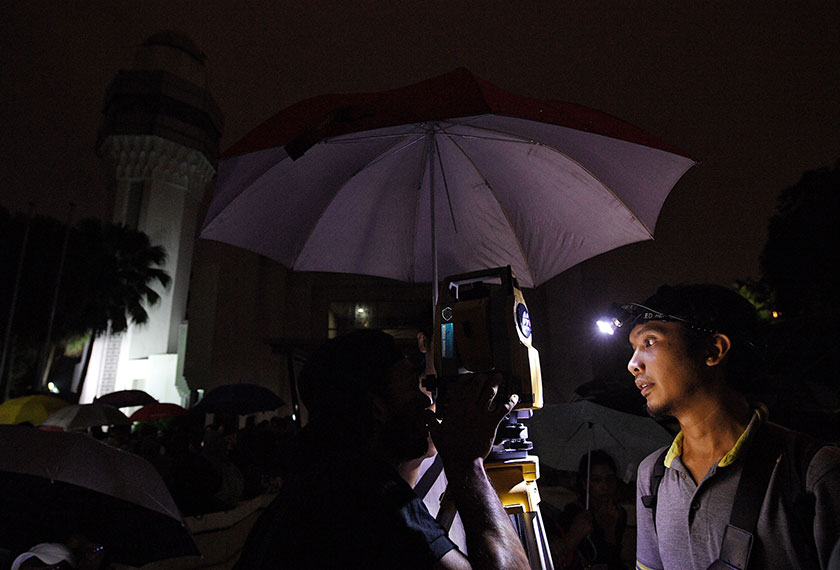 Pelajar Kolej Universiti Geomatika Mohd Shahir Halim (kanan) membetulkan kedudukan peralatan total station sebelum merakam tiga fenomena serentak yang akan berlaku ke atas bulan iaitu ‘Super Blue Blood-Moon’ di Planetarium Negara malam ini. - Foto Bernama