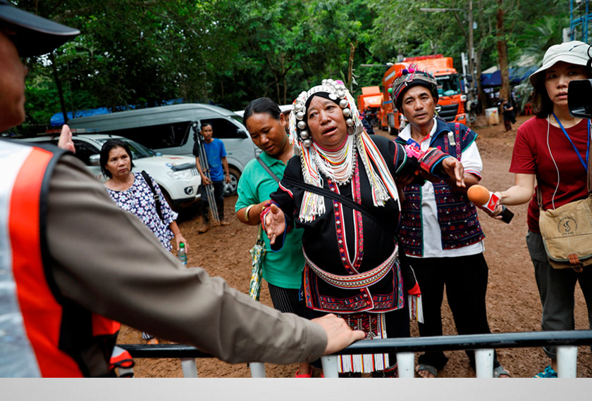 An ethnic Akha woman asks a police officer to be allowed to go in to pray for the return of the missing members of an under-16 soccer team and their coach, near the Tham Luang cave complex, as an ongoing search for them continues, in the northern province of Chiang Rai, Thailand, June 30, 2018. - REUTERS
