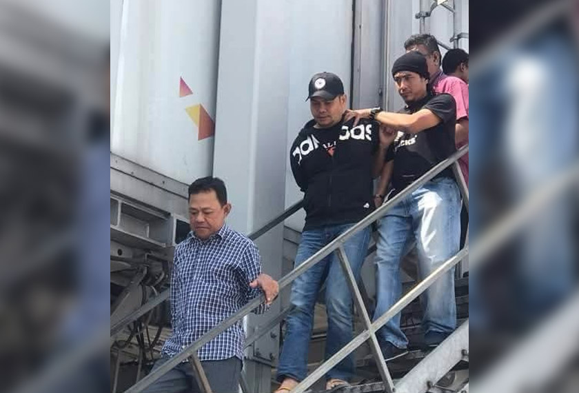 Jamal dibawa anggota polis keluar dari kapal terbang sebaik tiba di Lapangan Terbang Antarabangsa Kuala Lumpur hari ini. Foto ihsan pembaca