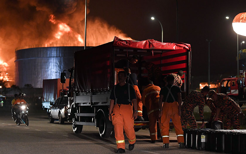 Anggota JBPM mengangkut tong yang mengandungi serbuk buih untuk digunakan bagi memadamkan kebakaran melibatkan tiga buah tangki minyak mentah milik KBC awal pagi tadi. --fotoBERNAMA