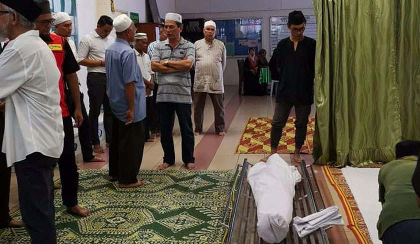 Mohd Israr (kanan) menatap jenazah ayahnya setelah selesai sembahyang jenazah di Masjid Taman Kosas hari ini. - Astro AWANI