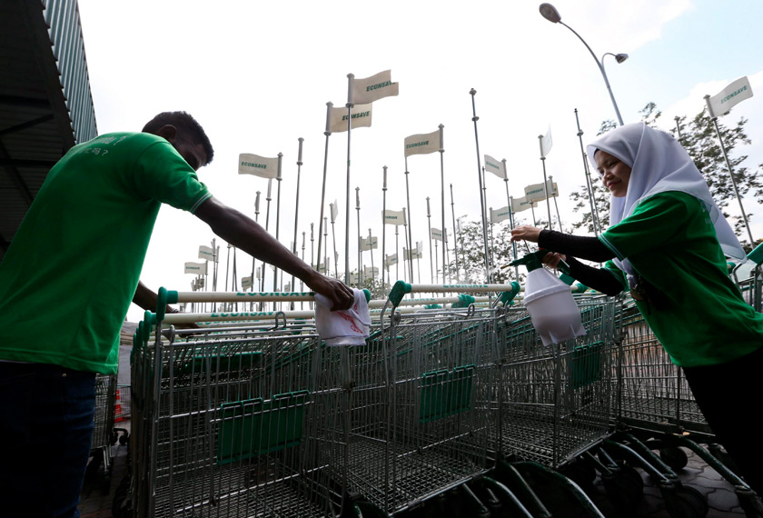 Pekerja-pekerja Pasar Raya Econsave memberi tumpuan pada bahagian pemegang troli ketika melakukan kerja disinfeksi suci hama di Pasar Raya Econsave Taman Daya hari ini. - BERNAMA