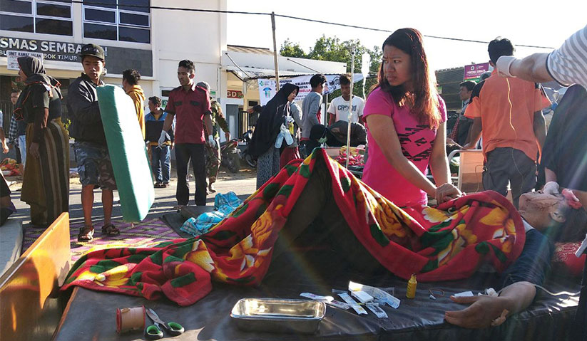 Orang ramai saling bantu membantu mangsa yang cedera akibat gempa bumi kuat melanda Pulau Lombok, Indonesia. - Foto Reuters