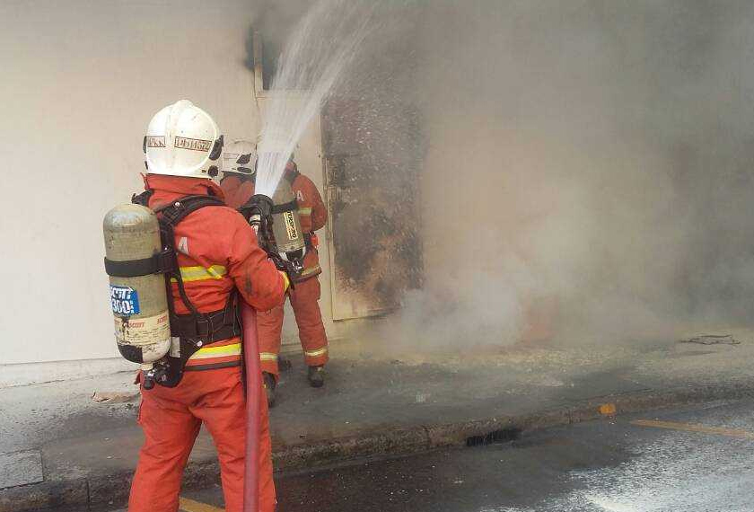 Anggota bomba berusaha memadam kebakaran kedai empat tingkat di Segama di sini. - Ihsan JBPM Sabah