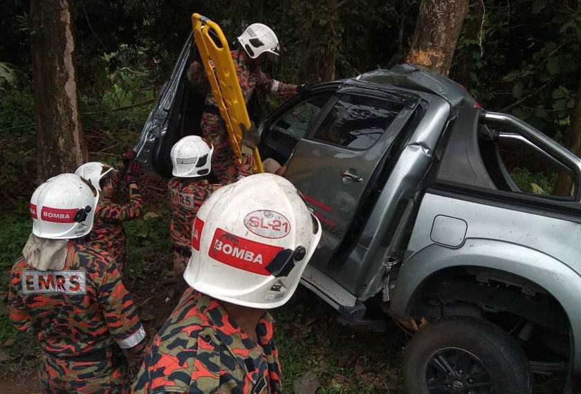 Anggota bomba berusaha mengeluarkan mangsa yang tersepit dalam kemalangan.