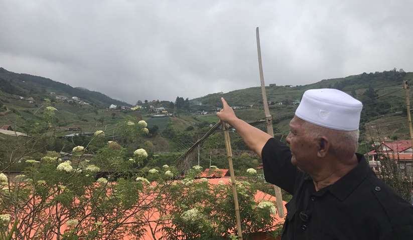 Abdul Wahab menunjukkan kepada gunung yang terlindung di sebalik awan tebal. Astro AWANI / TAN SU LIN