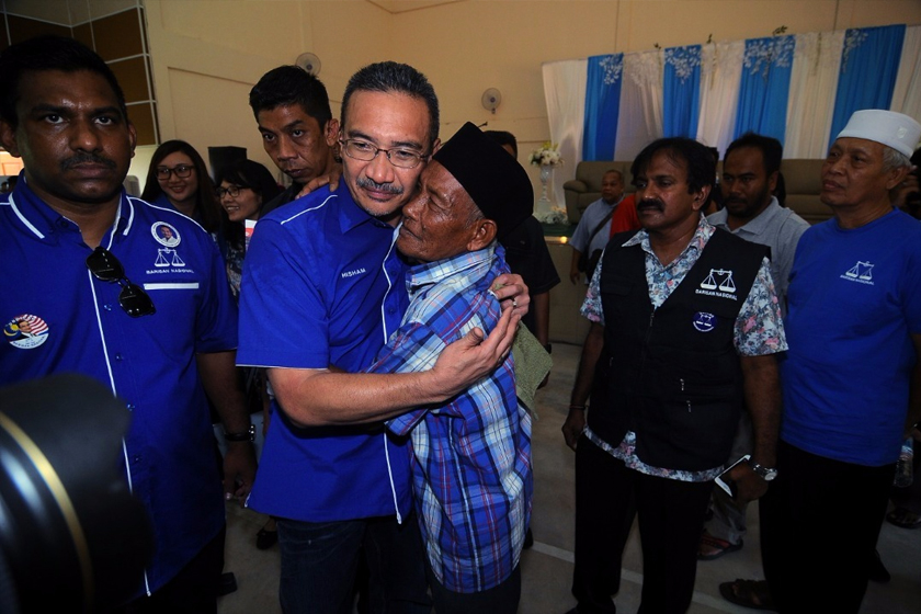 Hishammuddin mendakap seorang penduduk dalam lawatannya ke Bentong. - Foto Astro AWANI.