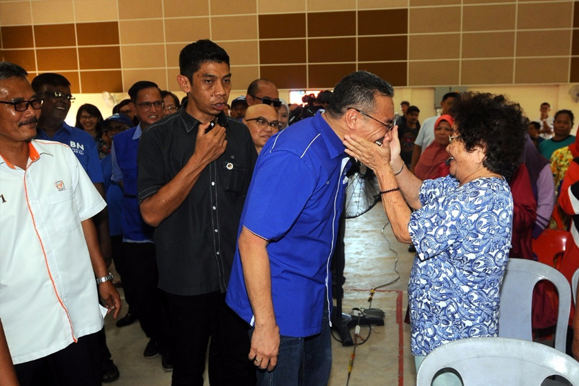 Seorang penduduk di Bentong memegang pipi Hishammuddin pada lawatannya ke Parlimen Bentong.