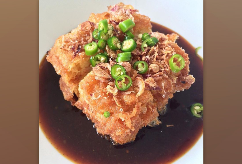 Inti di tengah-tengah tauhu itu mengandungi kentang yang sudah dihancurkan, potongan lobak, jagung dan kacang peas disediakan dengan sos pedas masam manis.