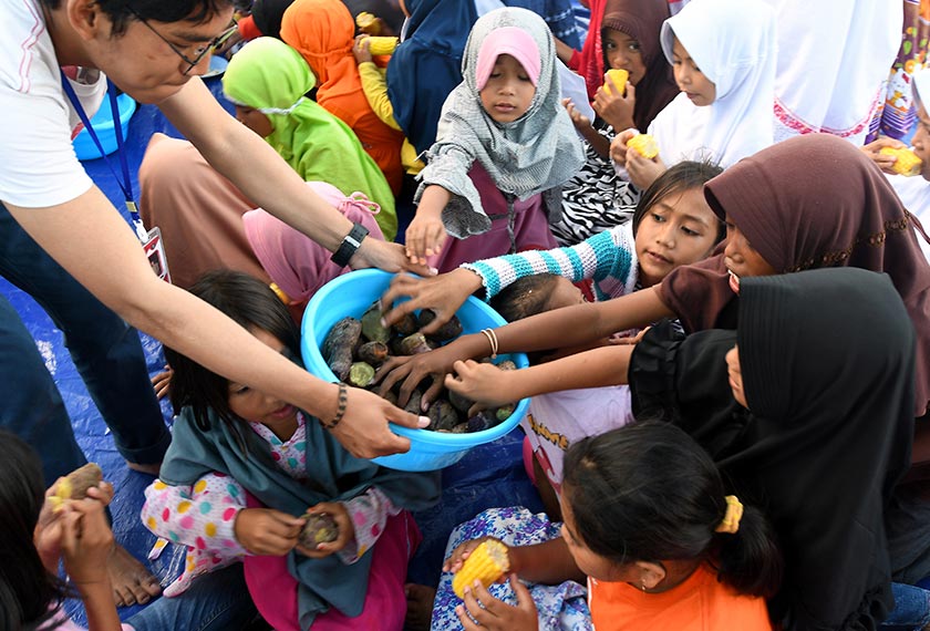 Sukarelawan daripada Sekolah Menengah Agama Negeri Model Terpadu Madani Palu, menjamu makanan kepada golongan kanak kanak selepas mengadakan aktiviti bersama mereka sempena Maulidur Rasul di khemah sementara di kampung Kabonena pada Selasa. - Bernama