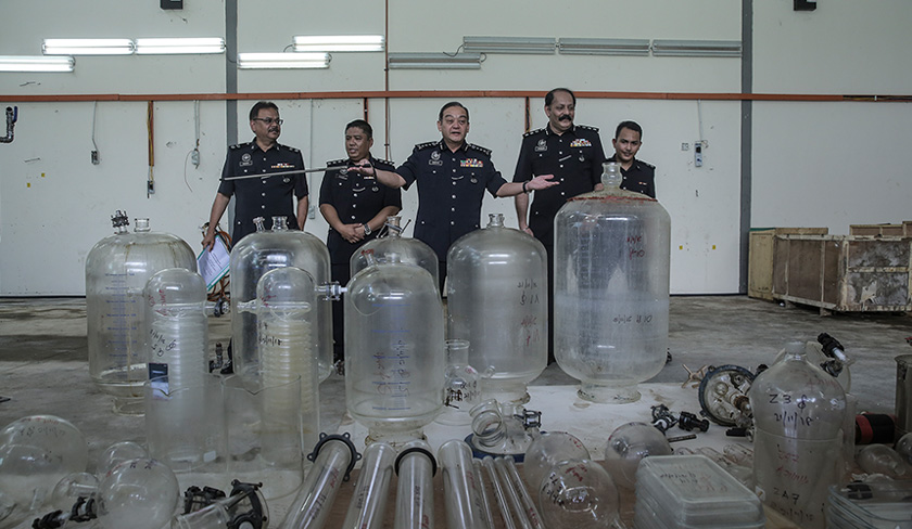 Mazlan (tengah) menunjukkan mesin atau peralatan yang digunakan untuk memproses dadah. - Astro AWANI/Shahir Omar