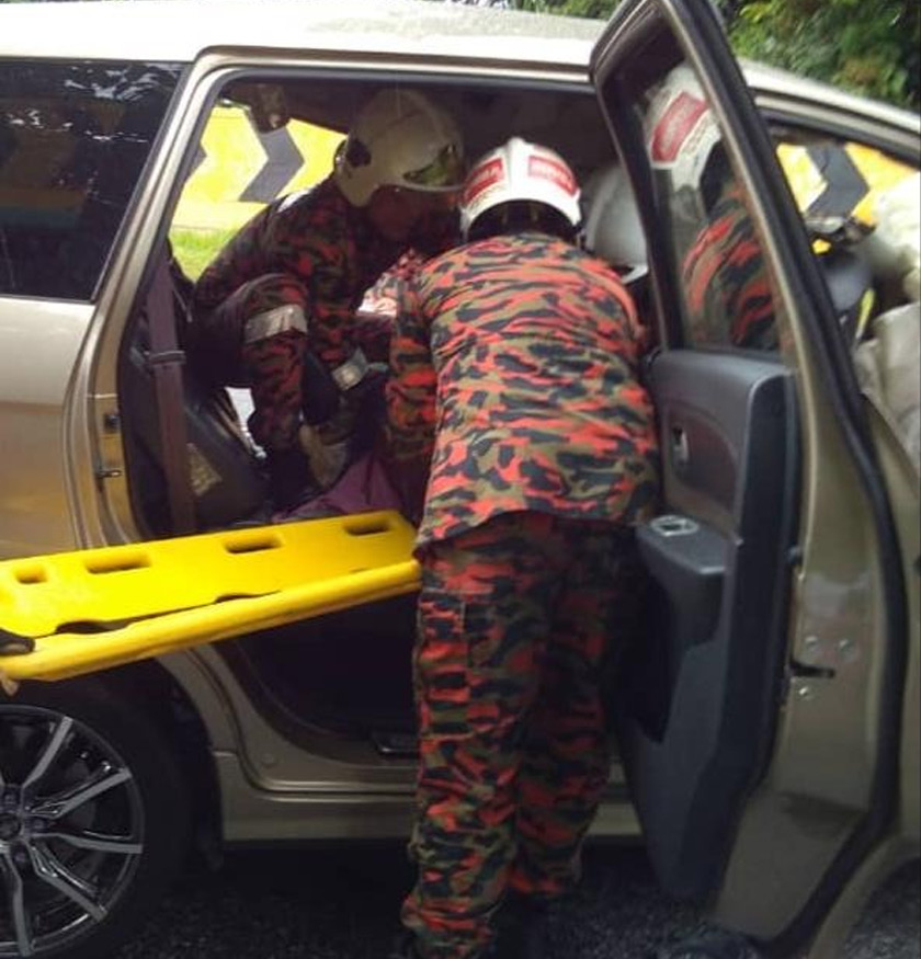 Pihak bomba sedang membantu mengangkat mangsa. - Foto JBPM