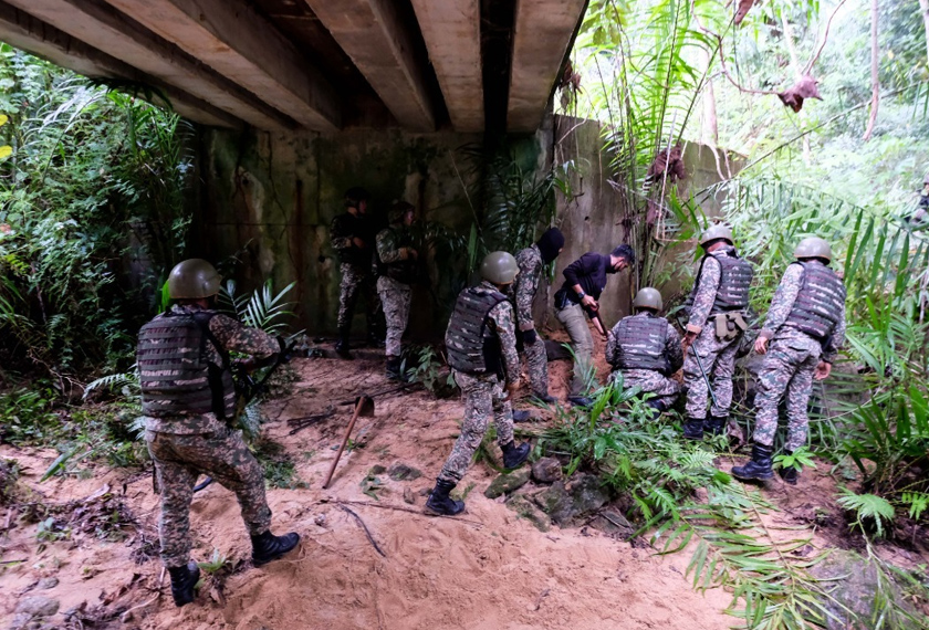 Pegawai dan anggota operasi menggunakan pengesan logam bagi mengesan bahan peledak. - Foto Astro AWANI/Fareez Azman