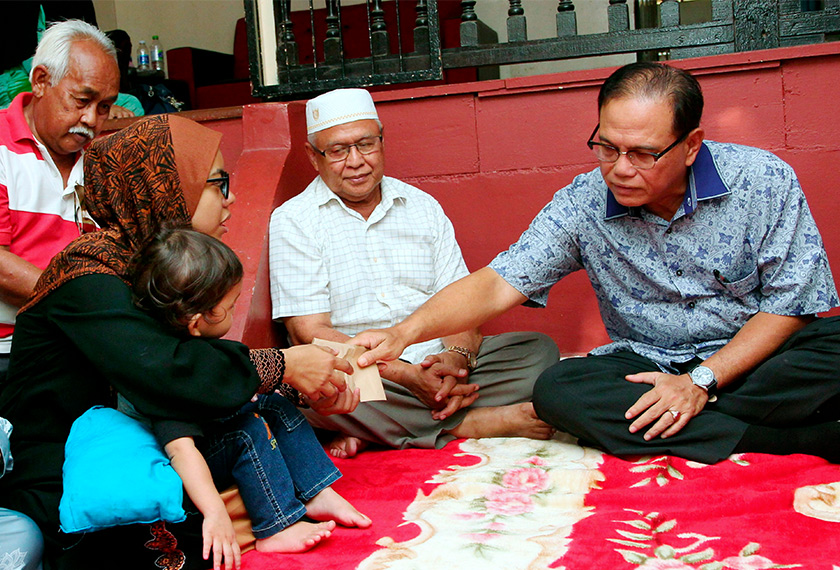 Wan Rosdy (kanan) menyampaikan sumbangan peribadi bagi meringankan beban kepada Noor Nadia (kiri) ketika menziarahi keluarga mangsa di Kampung Baru, Beserah, hari ini. - BERNAMA