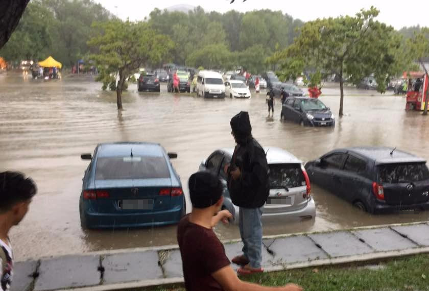 Keadaan kawasan parkir kenderaan yang dinaiki air sewaktu hujan lebat petang tadi. - Foto: Badru Hishan Mohd Zin/AwaniJR