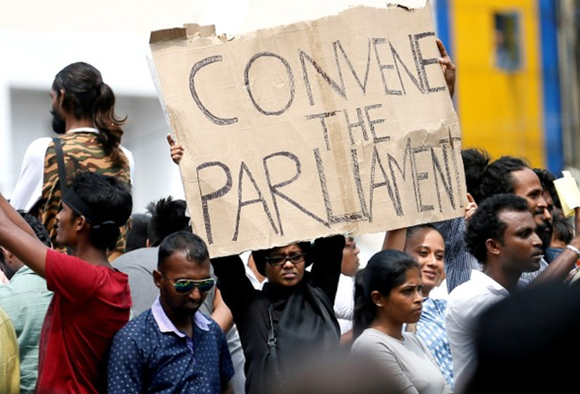Penyokong Ranil Wickremesinghe memegang poster ketika mengadakan tunjuk perasaan berhampiran kediaman rasmi perdana menteri di Colombo, Sri Lanka, 30 Okt, 2018. REUTERS